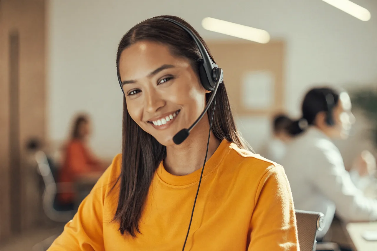 Atendente da HNET com fone de ouvido, sorrindo durante o atendimento